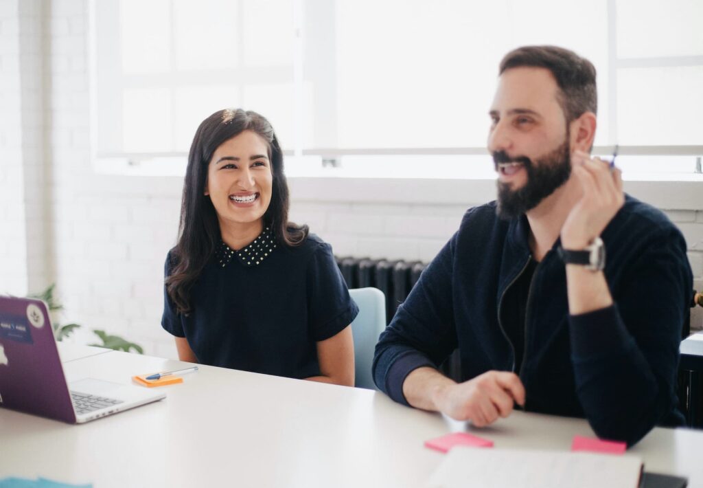 Two people working on an entry level HR certification at a desk