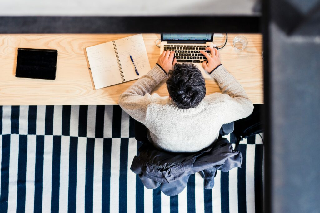 An overhead view of an HR professional studying continuing education for HR at his desk