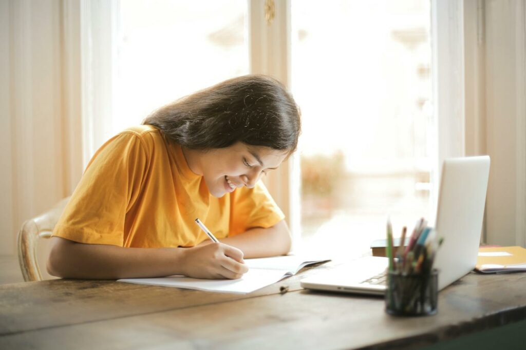 A woman studying at a desk about how to become a human resource manager