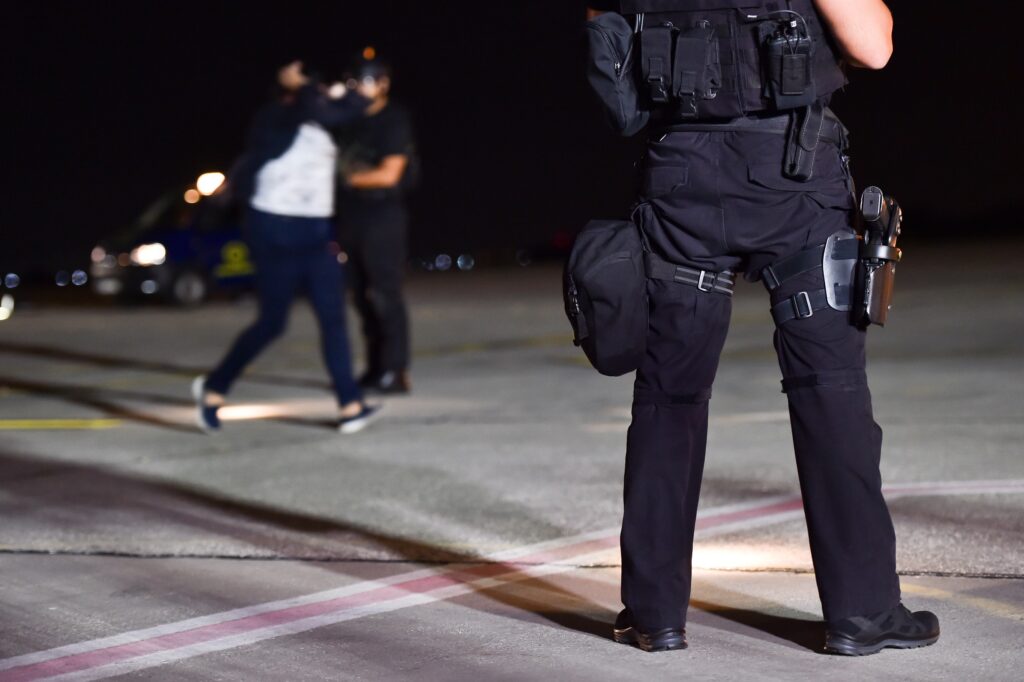 Two armed law enforcement officers standing outside of an active shooter situation