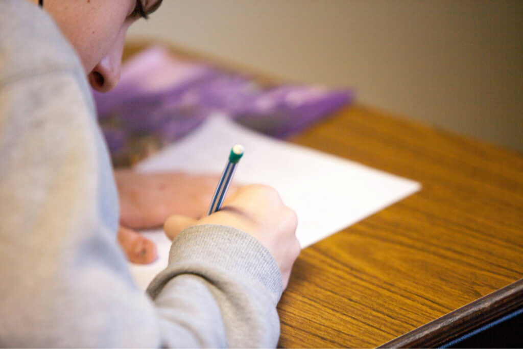 a person studying for an SPHR exam at a desk while they write on a paper