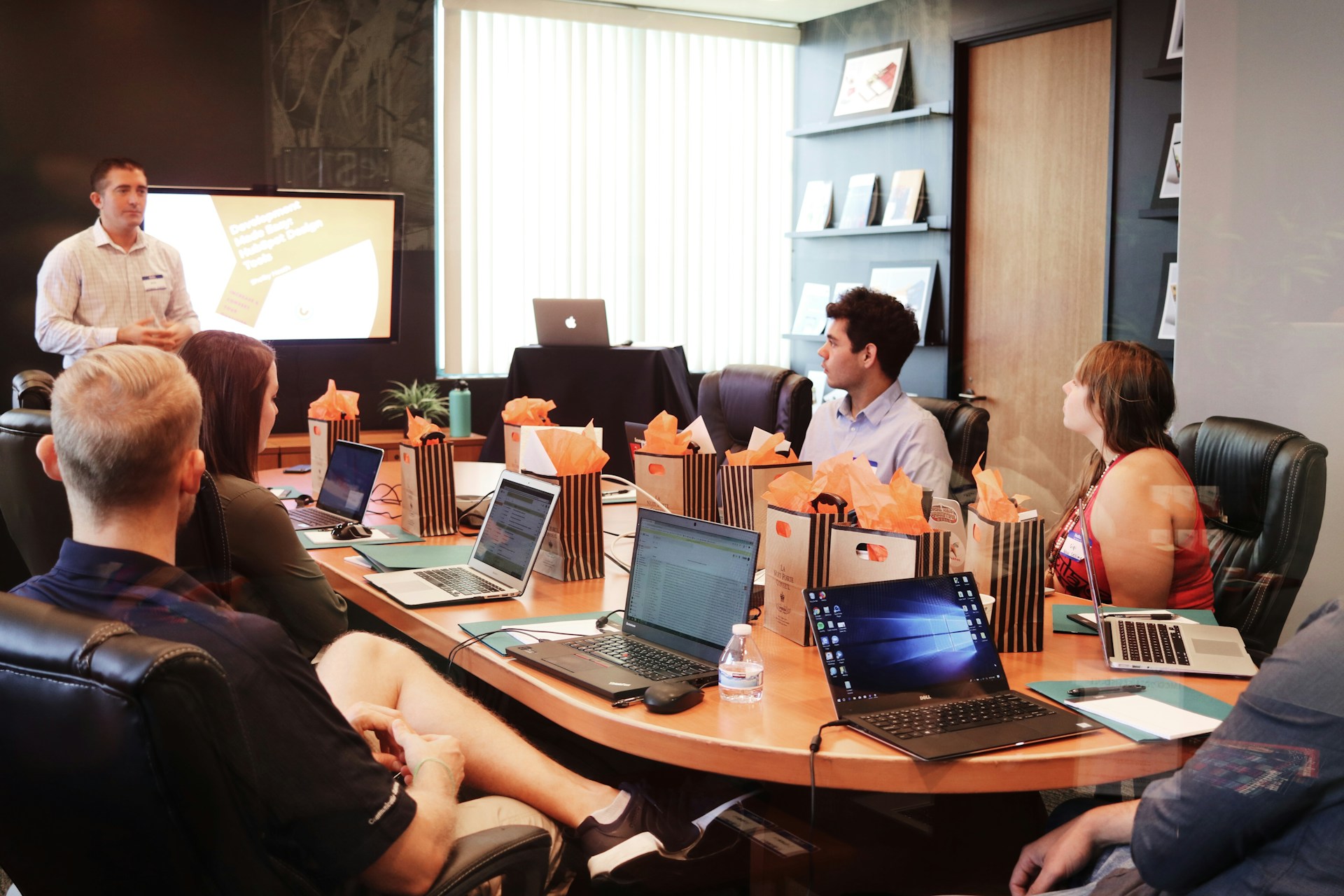 Employees Being Trained In A Conference Room With All Of Their Laptops Open