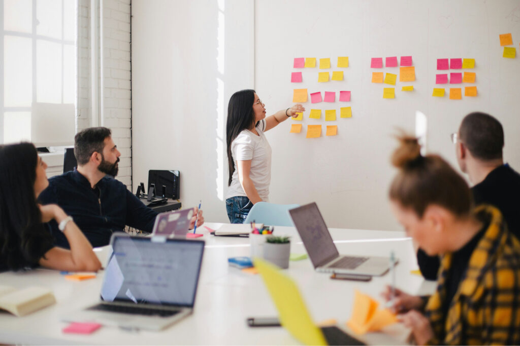 a woman leading a business meeting with ideas on sticky notes