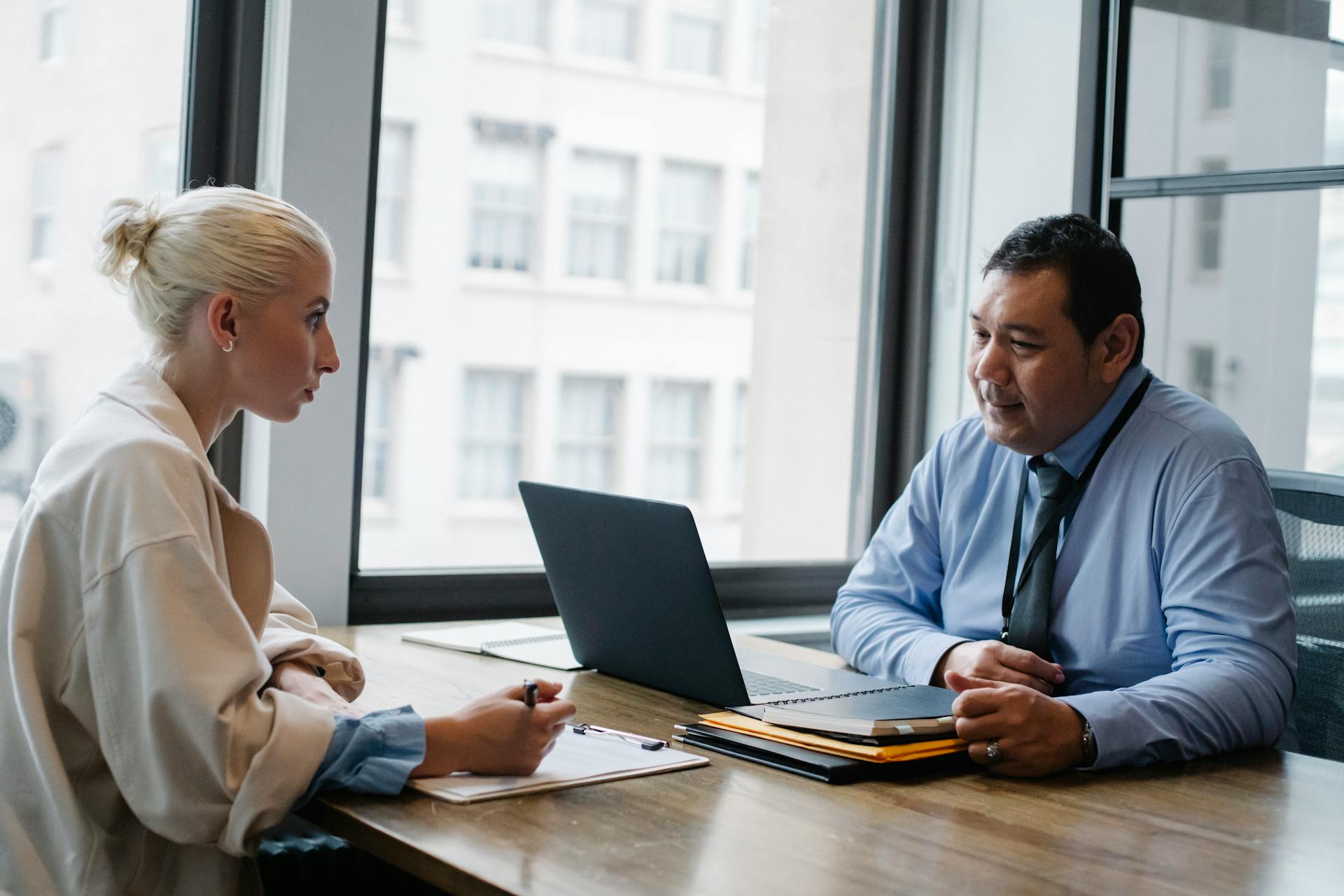 A Professional Man And A Woman In HR Talking At A Table