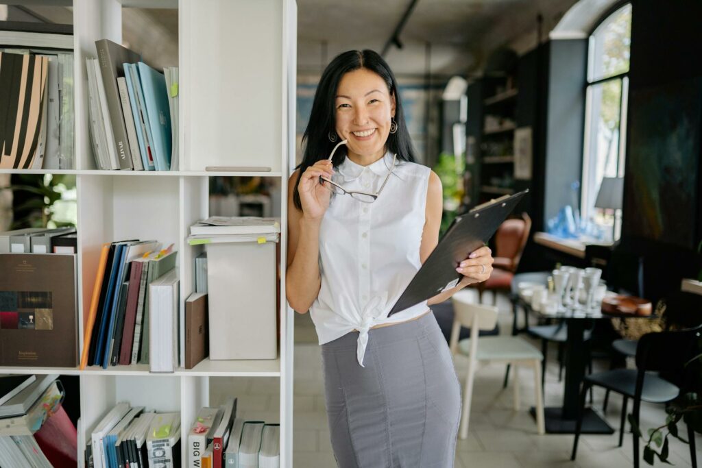 A woman smiling next to a bookcase in a professional work setting