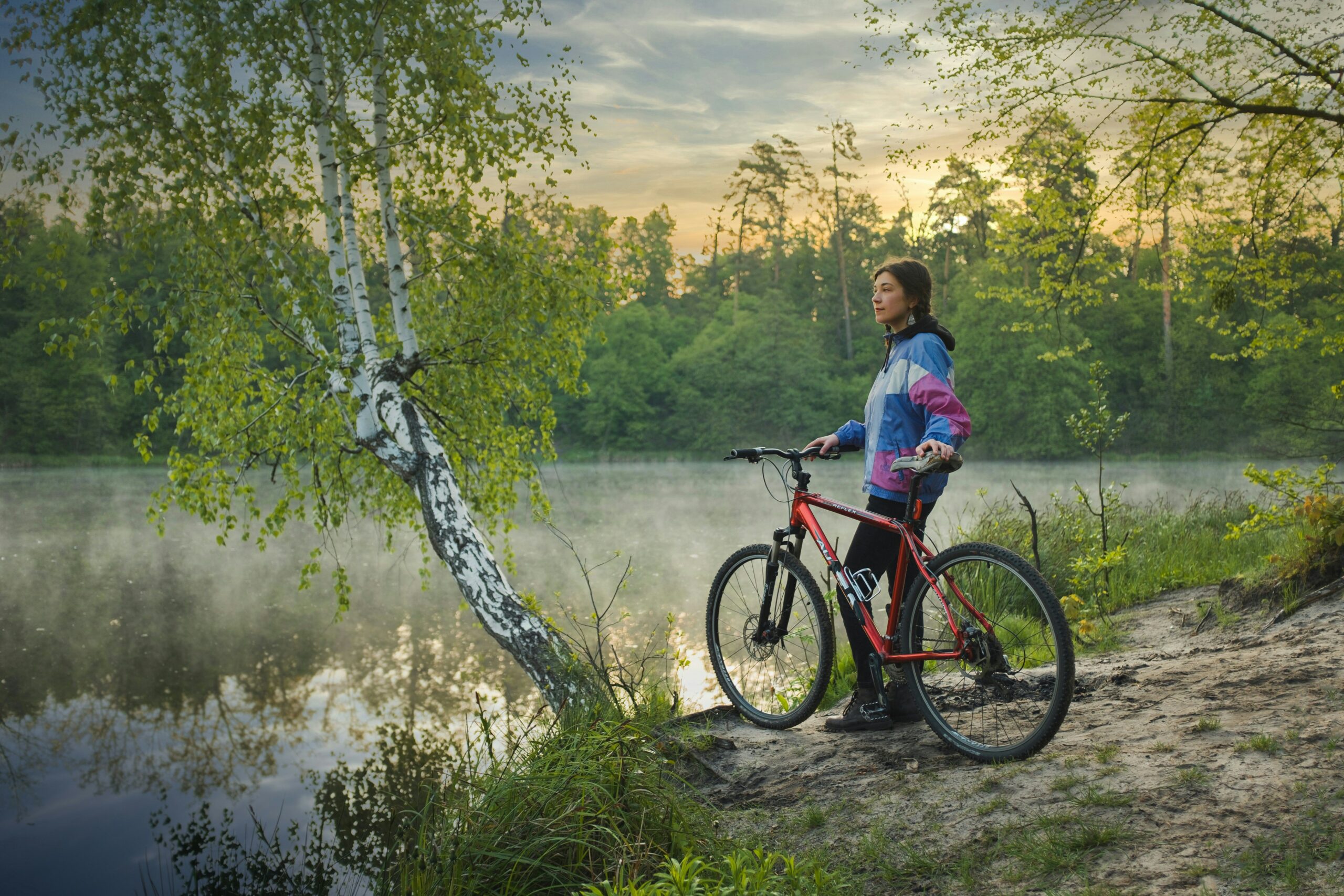 A Woman With A Bike By A Lake, Taking In The Vista